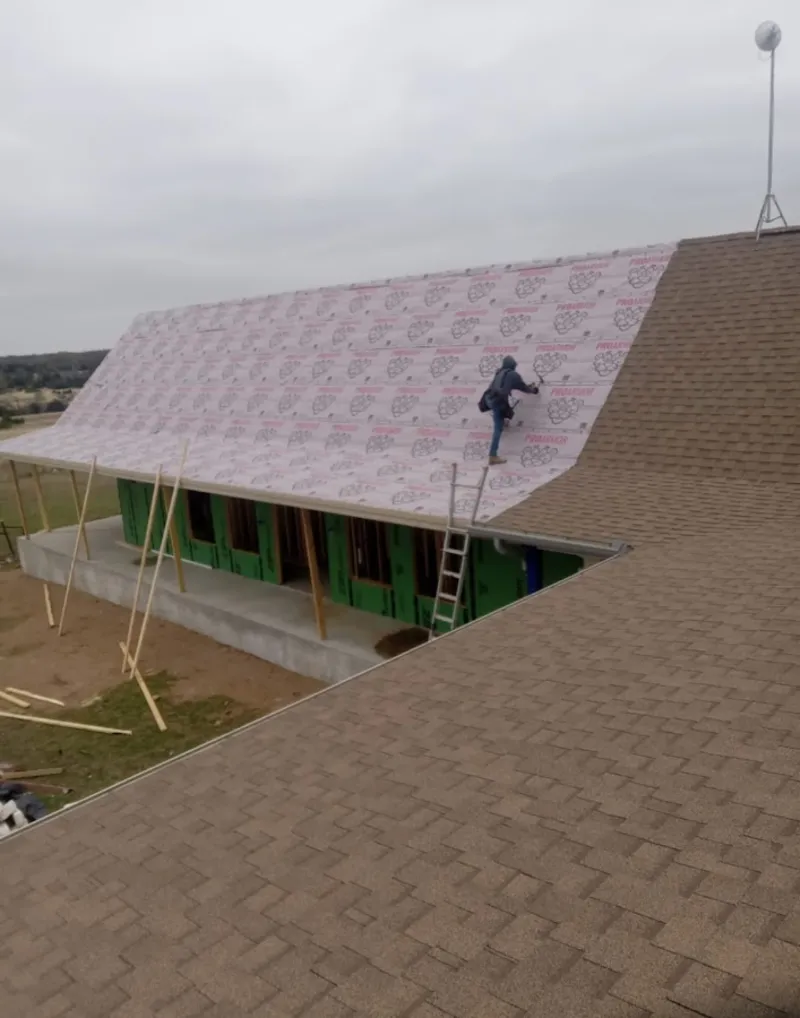 Worker preparing underlayment for a metal roof installation in Rocky River